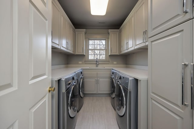 washroom with separate washer and dryer, sink, and cabinets