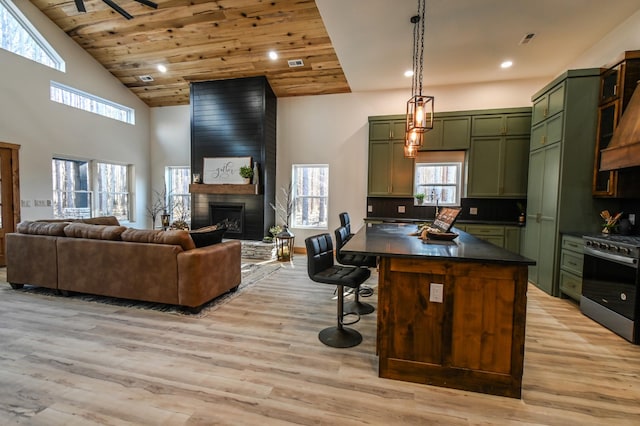 kitchen featuring wood ceiling, stainless steel range oven, green cabinetry, and light wood-type flooring