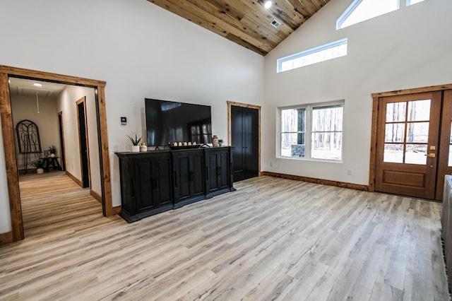 living room with a high ceiling, wooden ceiling, and light hardwood / wood-style flooring