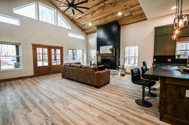 living room featuring a healthy amount of sunlight, wooden ceiling, and light hardwood / wood-style floors