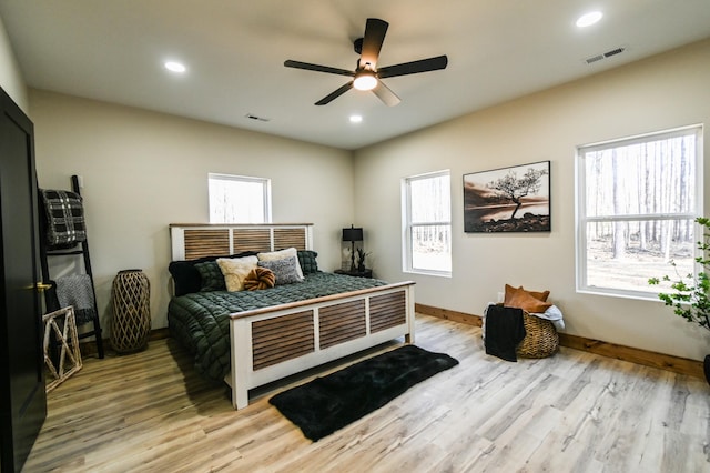 bedroom featuring multiple windows, ceiling fan, and light hardwood / wood-style flooring