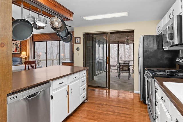 kitchen with white cabinetry, appliances with stainless steel finishes, light hardwood / wood-style flooring, and plenty of natural light