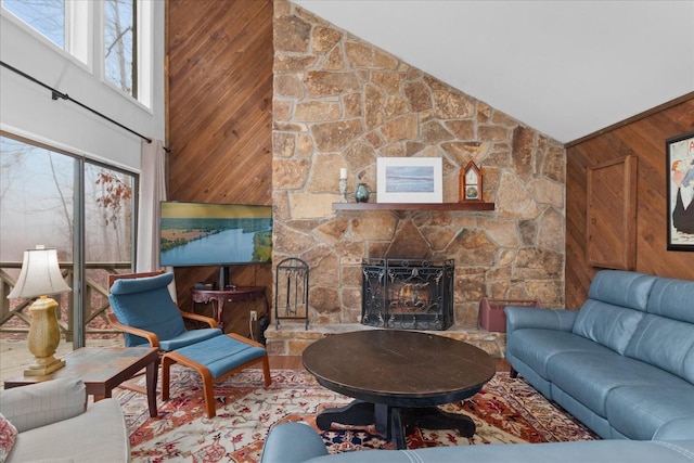 living room with a fireplace, high vaulted ceiling, and wood walls