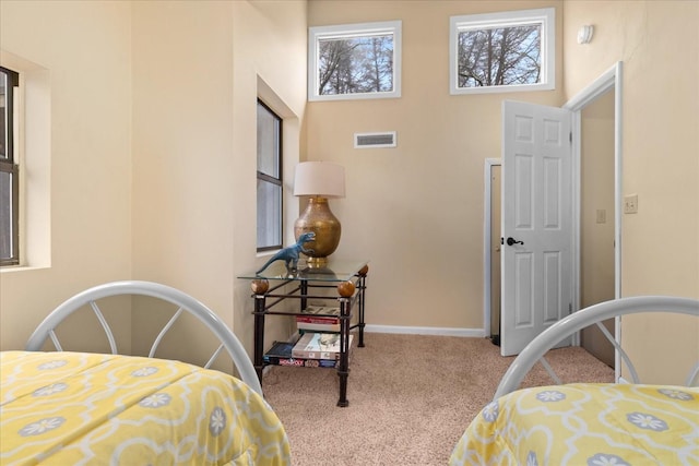 carpeted bedroom with a high ceiling