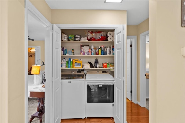 laundry area with washer and dryer and light wood-type flooring