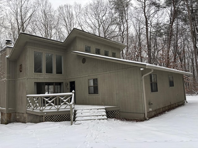 snow covered house with a wooden deck