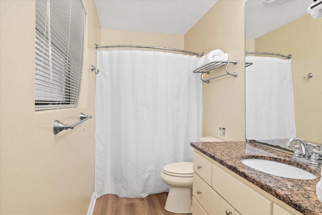 bathroom with wood-type flooring, toilet, and vanity