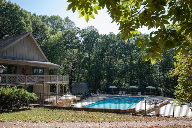 view of pool featuring a storage unit and a patio area