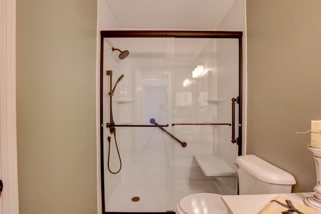 bathroom with a shower with door and toilet