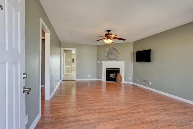 unfurnished living room featuring ceiling fan and light hardwood / wood-style flooring