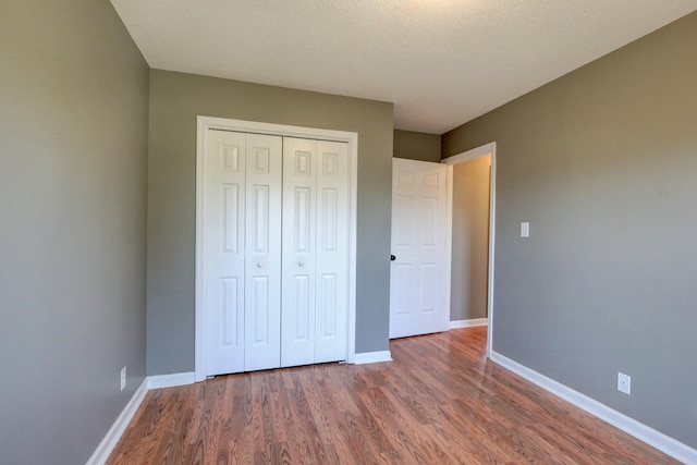 unfurnished bedroom featuring dark hardwood / wood-style floors and a closet