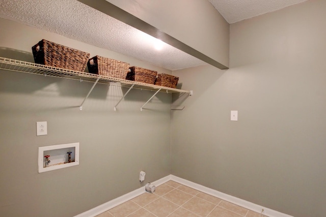 laundry room featuring tile patterned flooring, hookup for a washing machine, and a textured ceiling