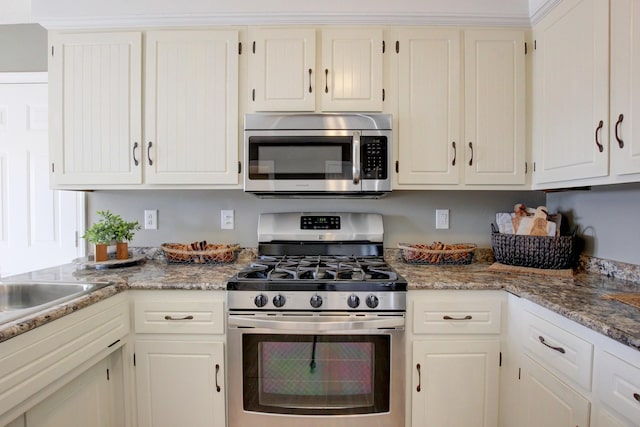 kitchen featuring white cabinetry, light stone countertops, stainless steel appliances, and sink