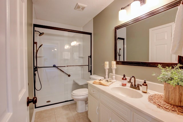 bathroom featuring vanity, toilet, a shower with shower door, and tile patterned flooring