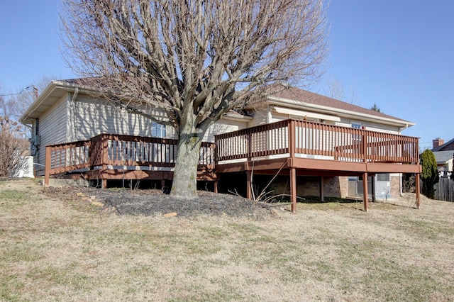 back of property with a wooden deck and a yard