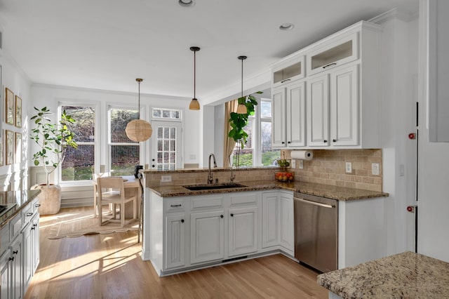 kitchen featuring sink, decorative light fixtures, stainless steel dishwasher, and white cabinets