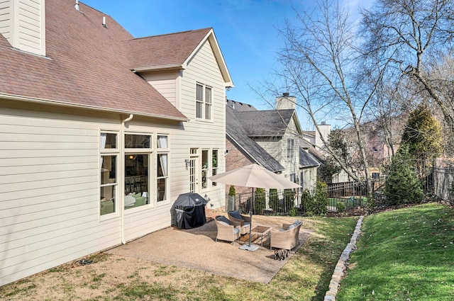 rear view of property featuring a patio area and a lawn