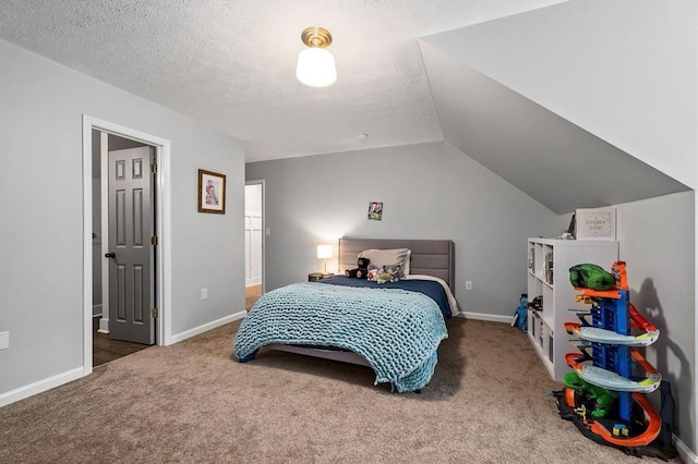 bedroom with vaulted ceiling, carpet floors, and a textured ceiling