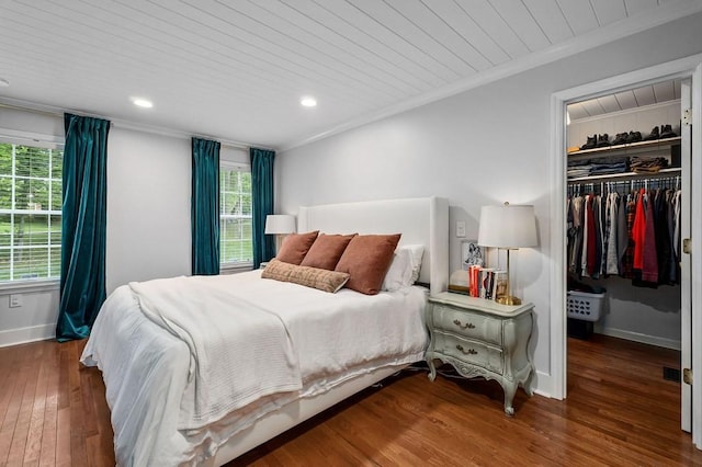 bedroom with crown molding, dark hardwood / wood-style flooring, a closet, and wooden ceiling