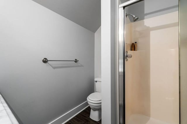 bathroom featuring lofted ceiling, toilet, and walk in shower