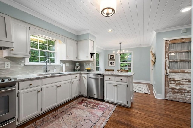 kitchen featuring appliances with stainless steel finishes, kitchen peninsula, pendant lighting, decorative backsplash, and white cabinets