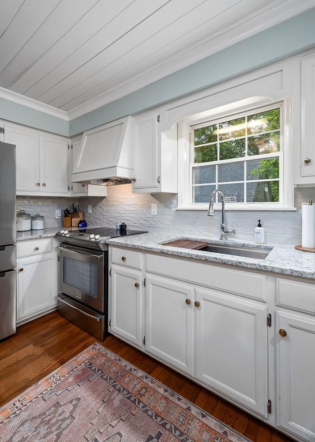 kitchen featuring premium range hood, white cabinetry, appliances with stainless steel finishes, and sink