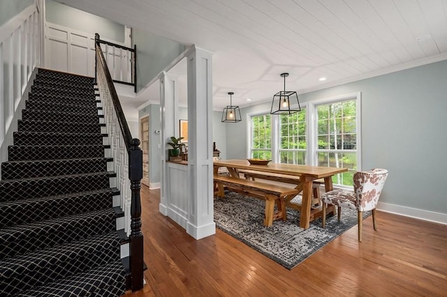 dining space with wood ceiling, wood-type flooring, ornamental molding, and ornate columns