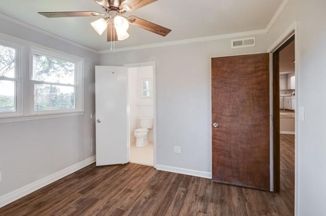 unfurnished bedroom with ensuite bathroom, crown molding, dark wood-type flooring, and ceiling fan