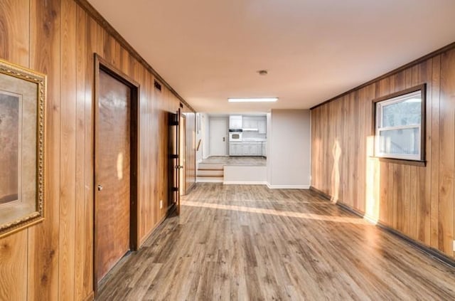 hallway featuring wood-type flooring and wood walls