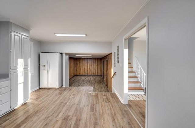 kitchen featuring light hardwood / wood-style flooring, ornamental molding, and white fridge with ice dispenser