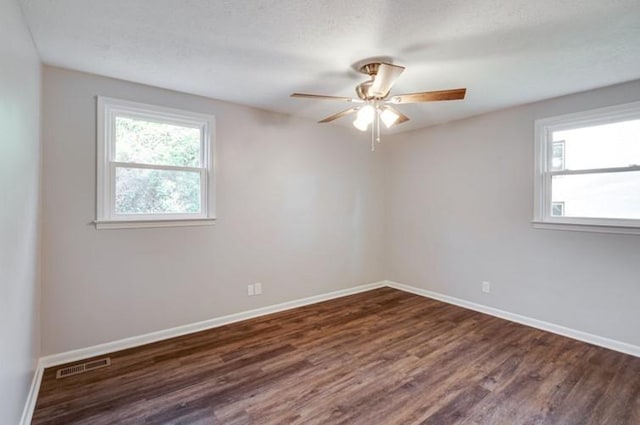 empty room with ceiling fan and dark hardwood / wood-style flooring