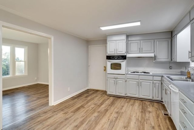 kitchen with crown molding, sink, white appliances, and light wood-type flooring