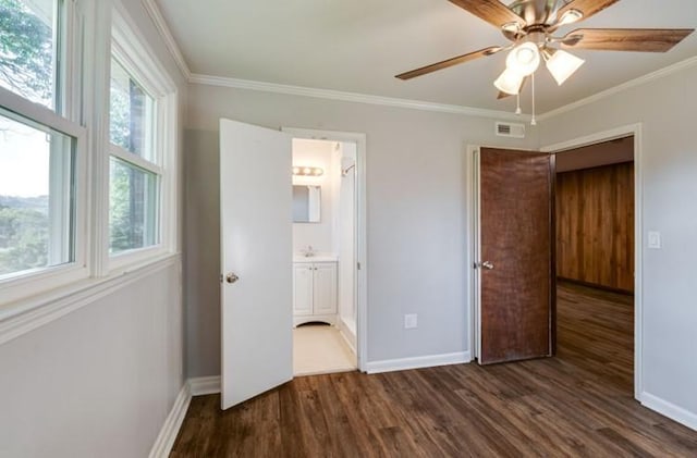 unfurnished bedroom featuring ensuite bathroom, dark hardwood / wood-style floors, crown molding, and ceiling fan