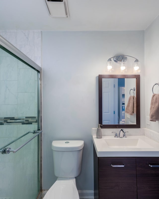 bathroom featuring vanity, an enclosed shower, and toilet