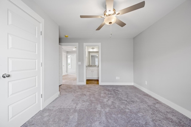 unfurnished bedroom featuring light carpet, ceiling fan, and ensuite bathroom