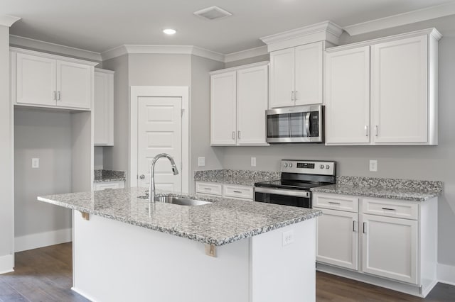 kitchen featuring an island with sink, appliances with stainless steel finishes, sink, and white cabinets