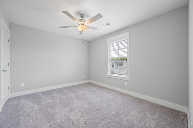 carpeted spare room featuring ceiling fan