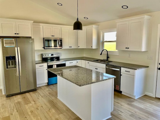 kitchen with sink, white cabinetry, a center island, dark stone countertops, and stainless steel appliances