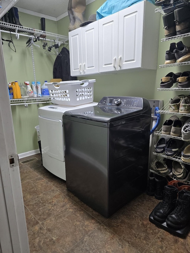 clothes washing area with cabinets and independent washer and dryer