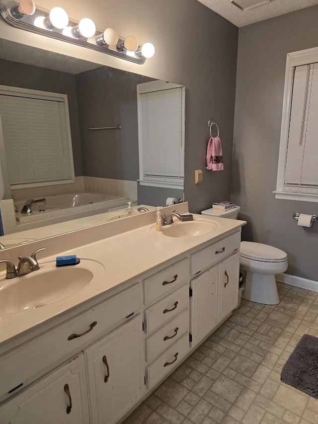 bathroom with vanity, a textured ceiling, and toilet