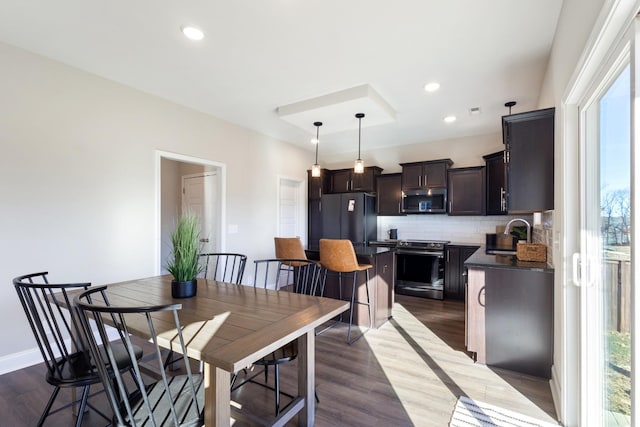 dining space with a healthy amount of sunlight, sink, and wood-type flooring