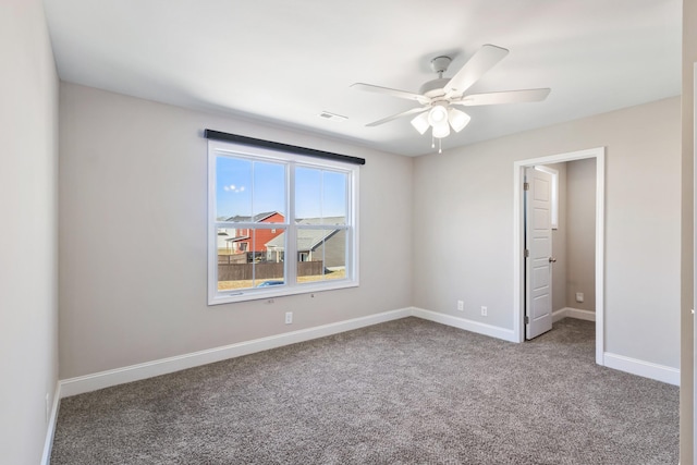 spare room featuring ceiling fan and carpet