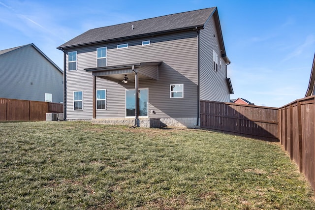 back of property with a yard, cooling unit, and ceiling fan