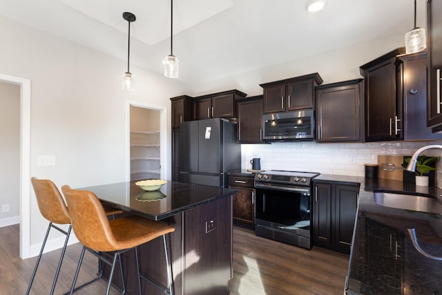 kitchen featuring sink, a breakfast bar area, decorative light fixtures, a center island, and stainless steel appliances