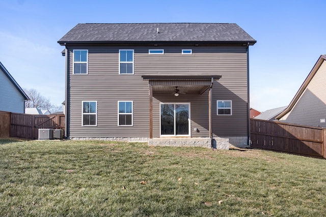 back of property with a yard, ceiling fan, and central air condition unit