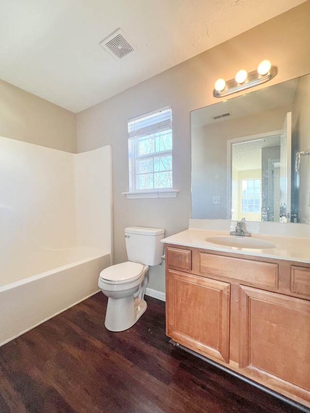 full bathroom with hardwood / wood-style flooring, vanity, toilet, and bathing tub / shower combination