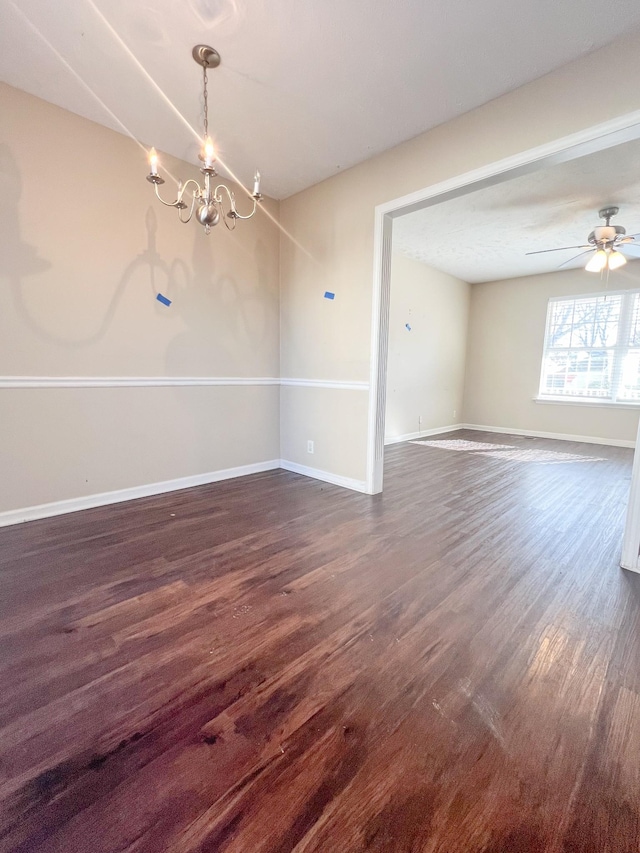 unfurnished dining area with dark hardwood / wood-style floors and ceiling fan with notable chandelier