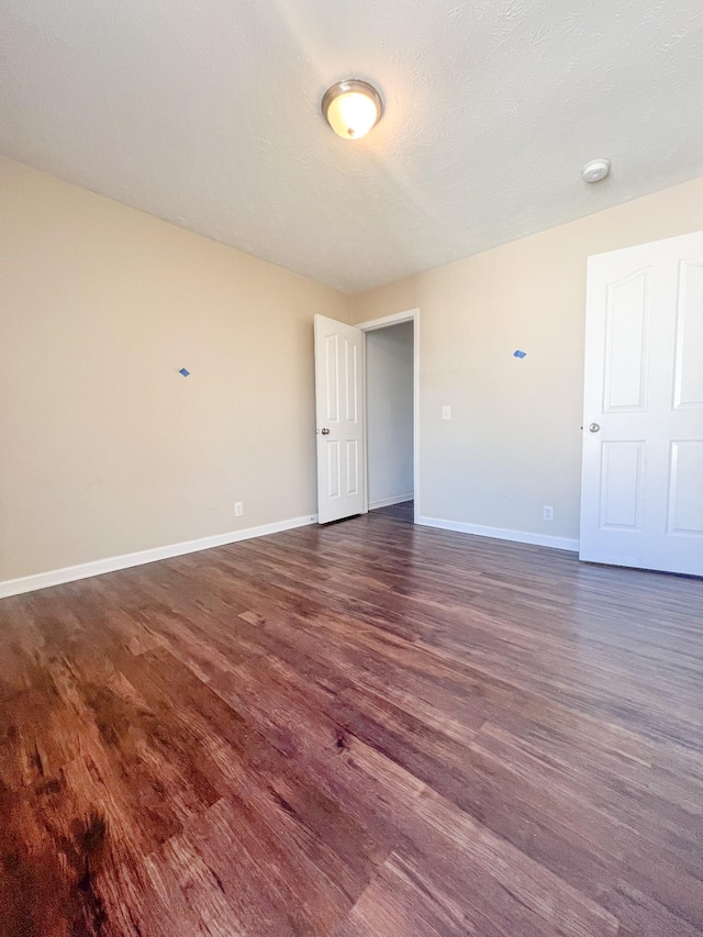 spare room with dark hardwood / wood-style flooring and a textured ceiling