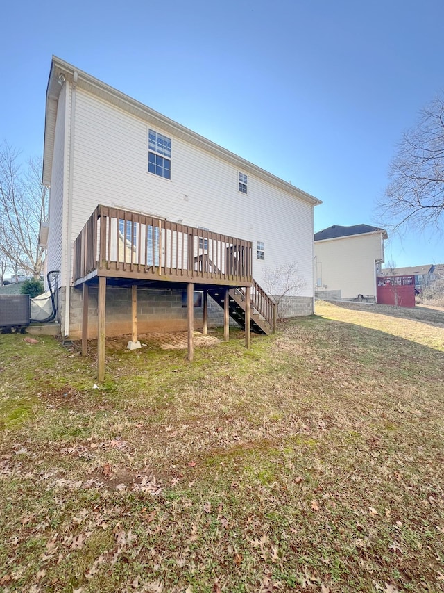 back of property featuring a deck and a lawn