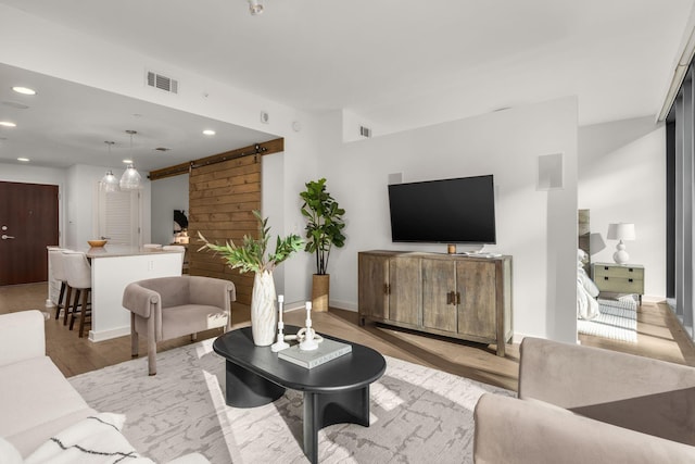 living room featuring a barn door and light hardwood / wood-style floors